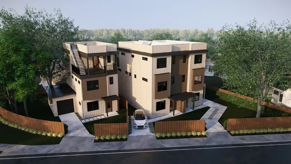 an aerial view of residential houses with outdoor space and parking