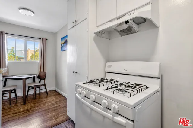 a white stove top oven sitting inside of a kitchen