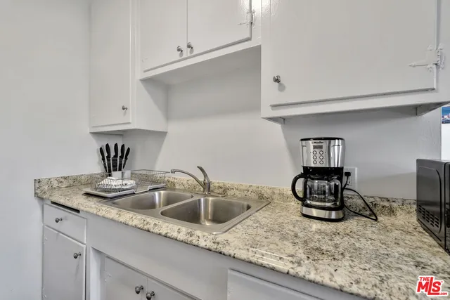 a kitchen with sink a stove and cabinets