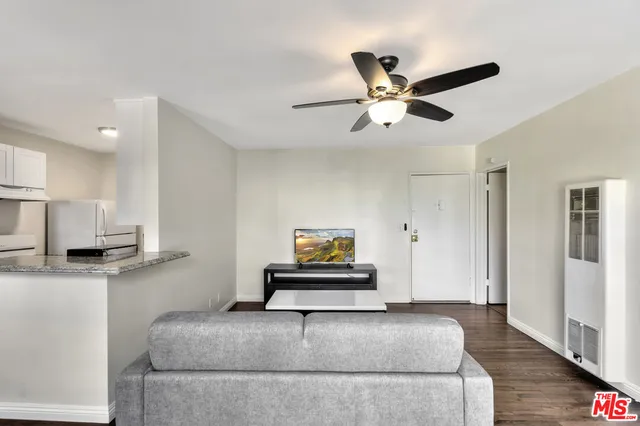 a living room with stainless steel appliances furniture and a chandelier
