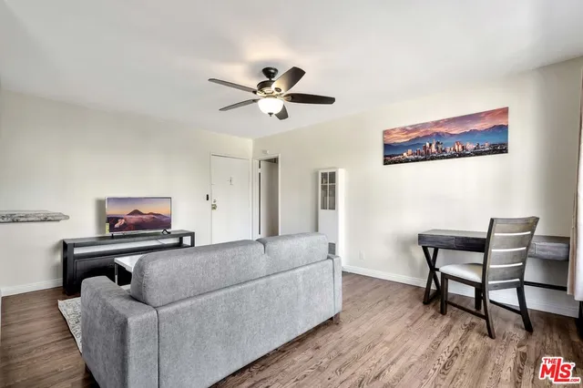 a living room with furniture and a ceiling fan