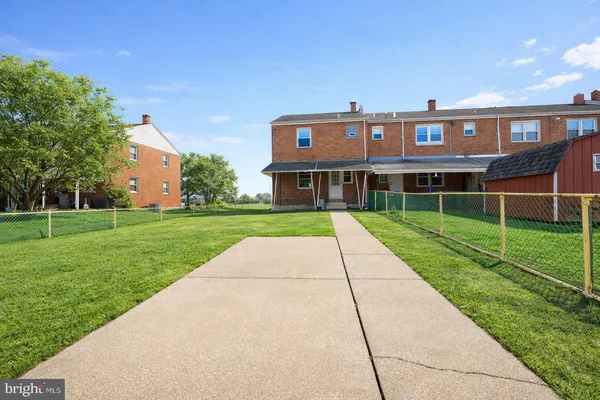 a view of a big building with a big yard and large trees