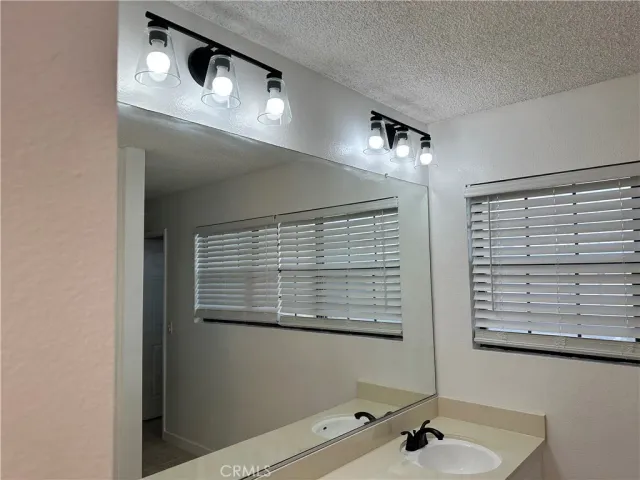 a bathroom with a sink a mirror and a window