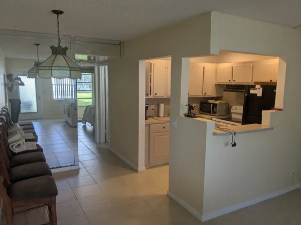 a kitchen with stainless steel appliances a refrigerator a sink a stove and white cabinets