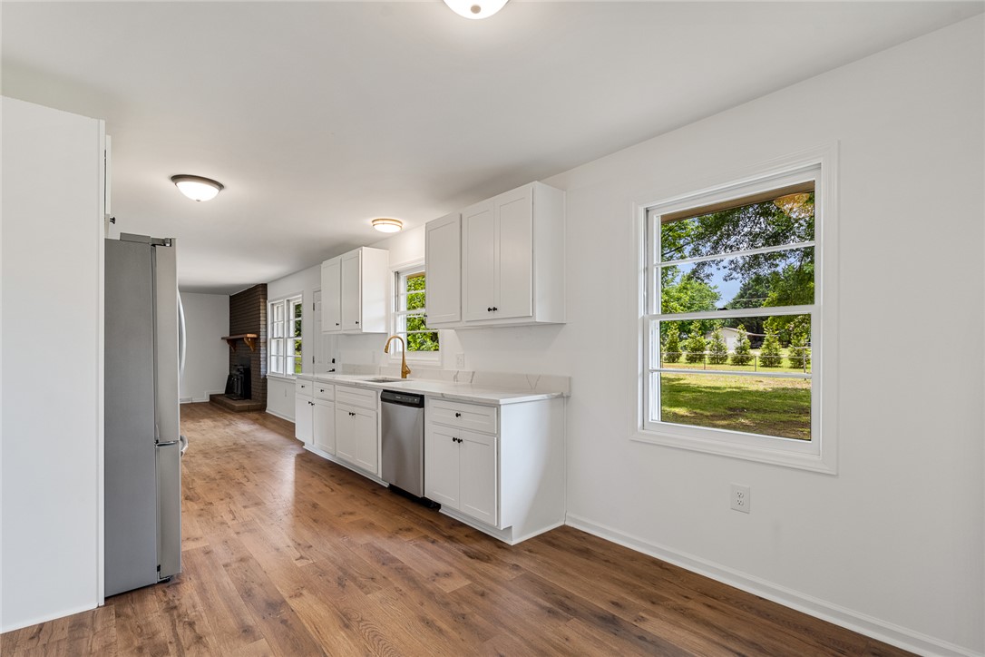 300 Vandiver Road Anderson, SC 29621 - Photo 13 of 30 A well-lit kitchen with gleaming new appliances and rich hardwood-style flooring.
