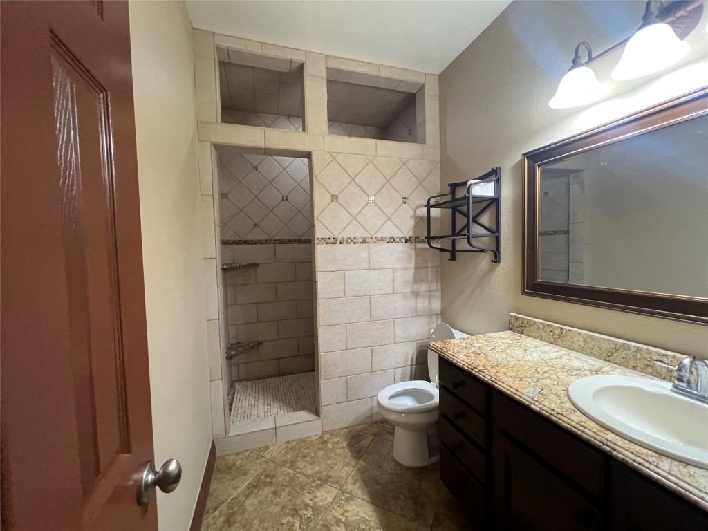 665 Wilson Road Red Rock, TX 78662 - Photo 13 of 34 Full bath with walk in shower, vanity, and a textured wall