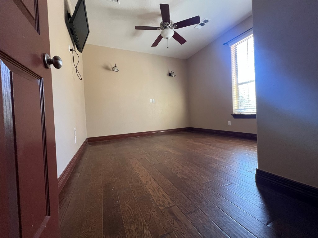665 Wilson Road Red Rock, TX 78662 - Photo 14 of 34 Empty room featuring dark wood-style flooring and ceiling fan