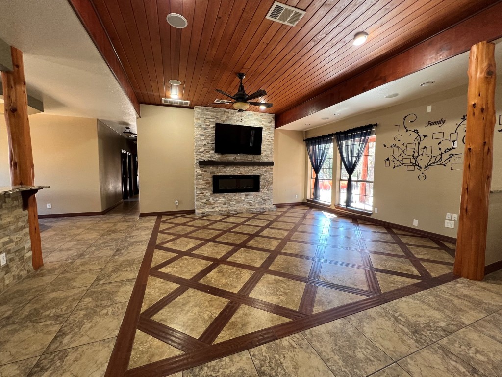 665 Wilson Road Red Rock, TX 78662 - Photo 19 of 34 Unfurnished living room with wood ceiling, a fireplace, inlaid floor details, and a ceiling fan