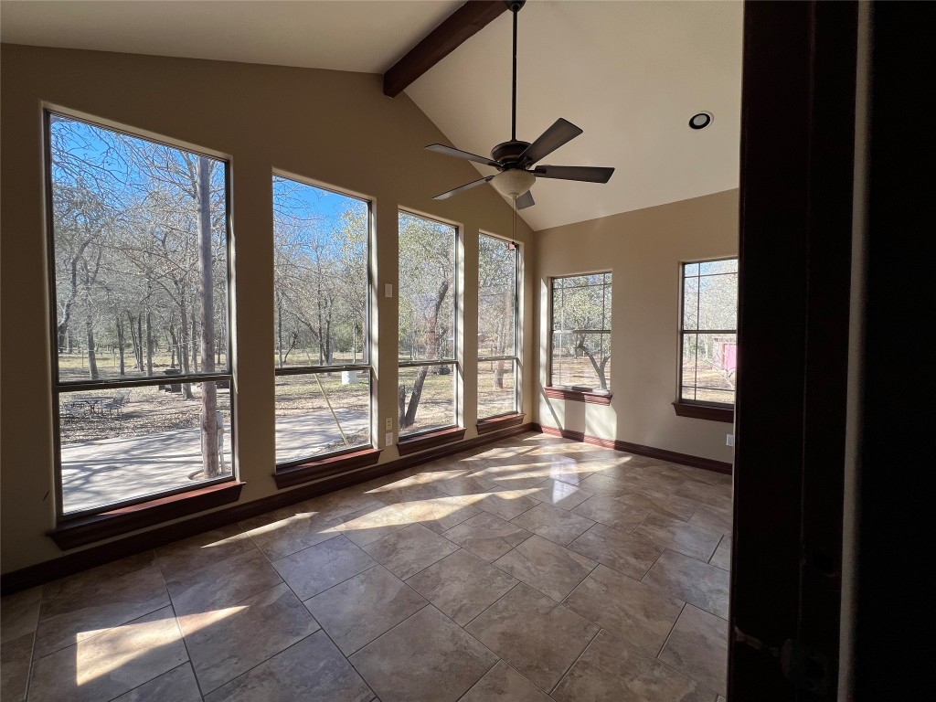665 Wilson Road Red Rock, TX 78662 - Photo 25 of 34 Unfurnished sunroom with beam ceiling, high vaulted ceiling, and stone finish floors