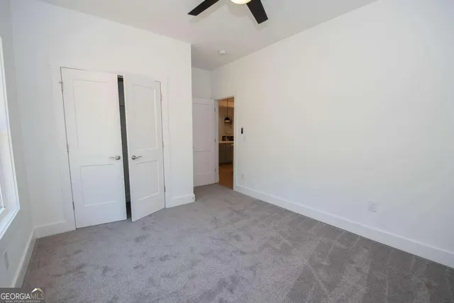 an empty room with closet and chandelier fan
