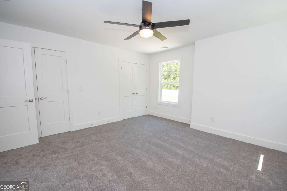 5 Firefly Run LaGrange, GA 30240 - Photo 38 of 53 an empty room with windows and chandelier fan