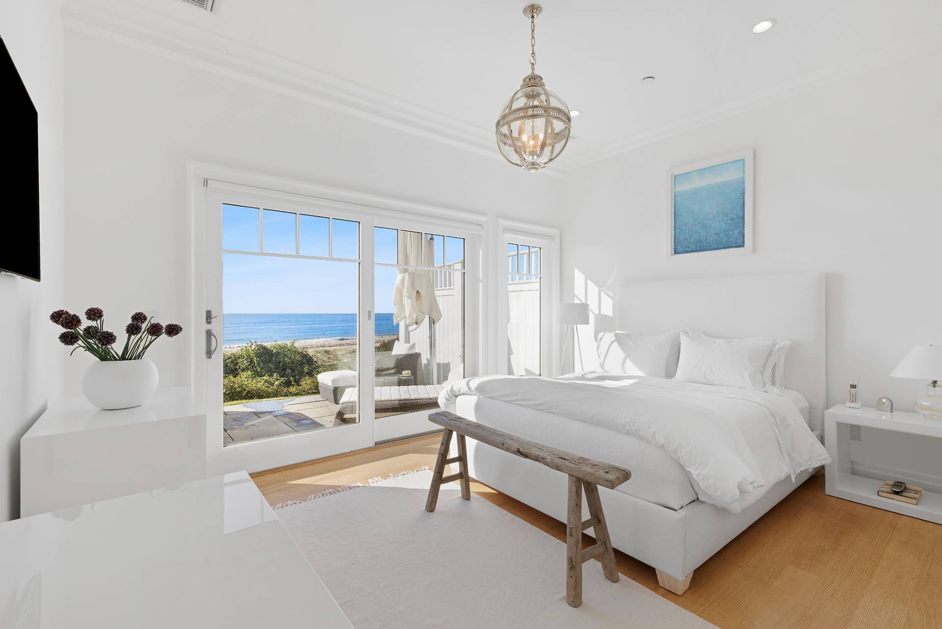272 Old Montauk Highway Montauk, NY 11954 - Photo 13 of 25 a bedroom with a bed and a chandelier