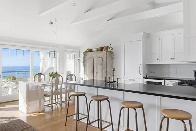 a kitchen with stainless steel appliances granite countertop a table chairs and a refrigerator