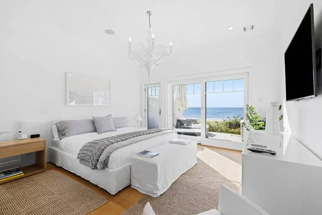 a spacious bedroom with a bed and a flat screen tv