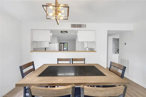 a view of kitchen island with sink refrigerator dining table and chairs