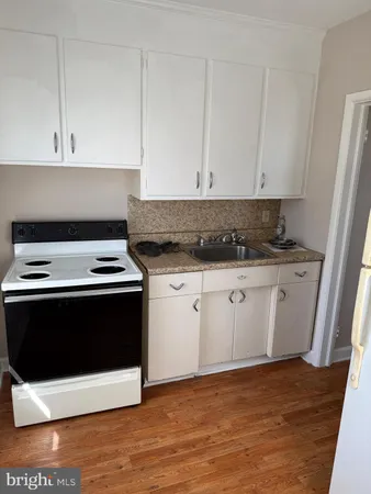 a kitchen with granite countertop white cabinets and white appliances