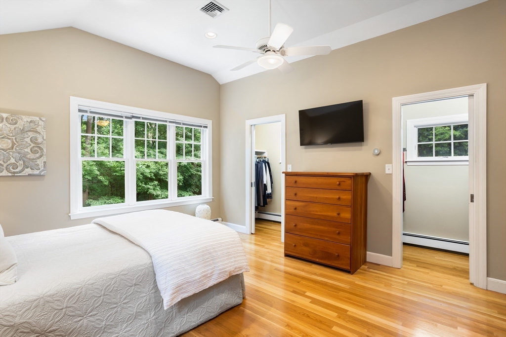 21 Grasshopper Lane Acton, MA 01720 - Photo 20 of 38 a bedroom with a bed a flat screen tv and a chandelier