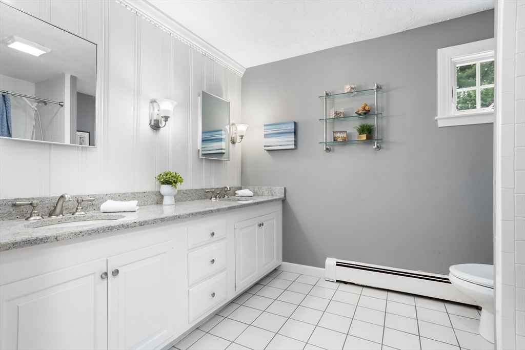 21 Grasshopper Lane Acton, MA 01720 - Photo 26 of 38 a bathroom with a granite countertop sink and a mirror