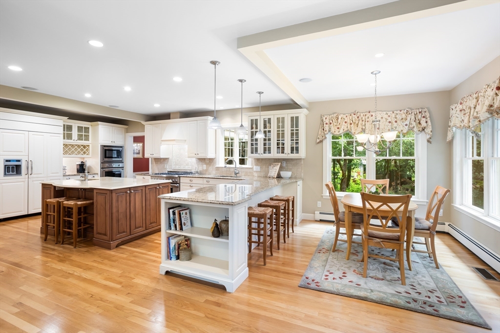 21 Grasshopper Lane Acton, MA 01720 - Photo 4 of 38 a kitchen with a stove a sink a kitchen island with chairs and wooden floor