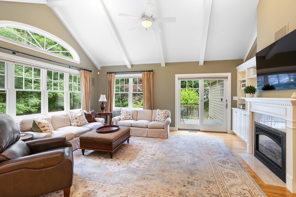 21 Grasshopper Lane Acton, MA 01720 - Photo 9 of 38 a living room with furniture a flat screen tv and a fireplace