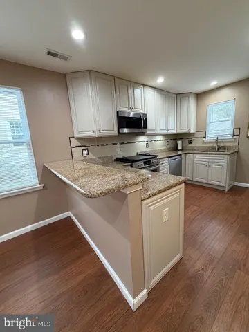 a kitchen with stainless steel appliances granite countertop a stove a sink and a microwave