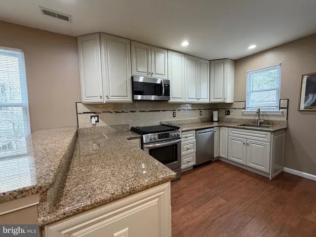 a kitchen with a sink stove and microwave