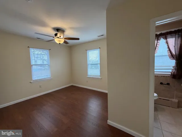 a view of room with hardwood floor and a ceiling fan