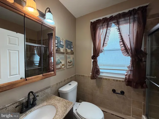 a bathroom with a sink toilet a mirror and shower
