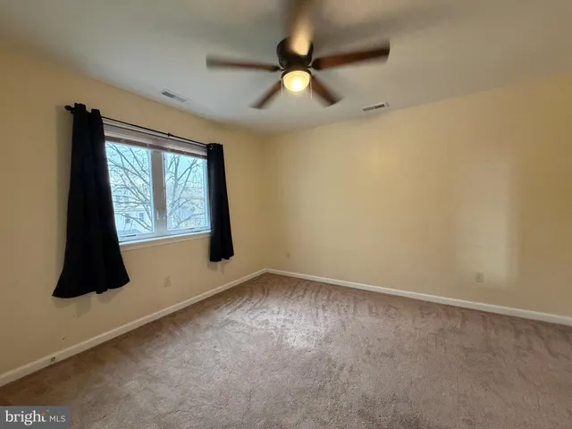 an empty room with windows and fan