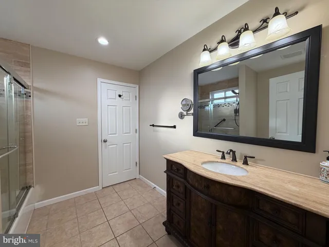 a bathroom with a double vanity sink mirror and shower
