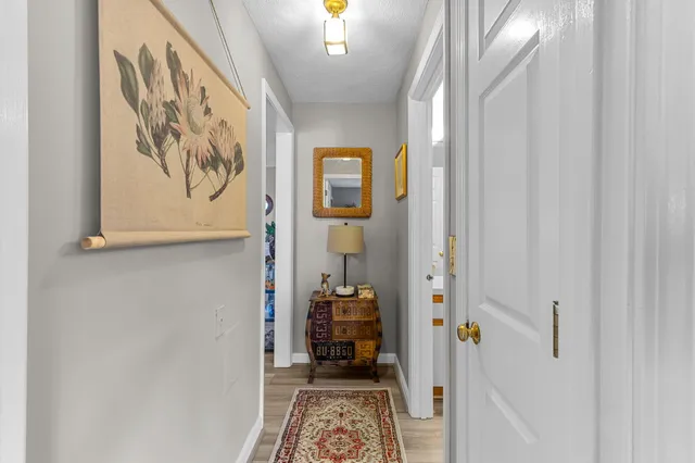 a hallway with painting on the wall and a large mirror