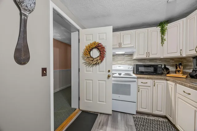 a kitchen with white cabinets and appliances