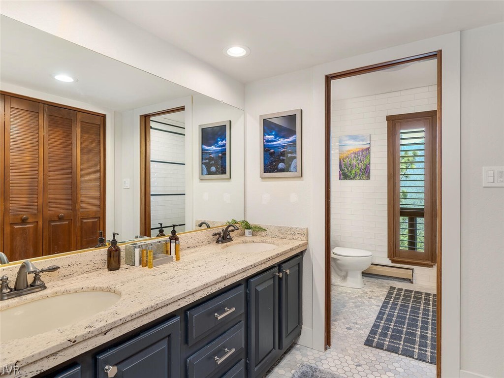 751 Champagne Road Incline Village, NV 89451 - Photo 22 of 30 a spacious bathroom with a granite countertop sink a mirror and a toilet