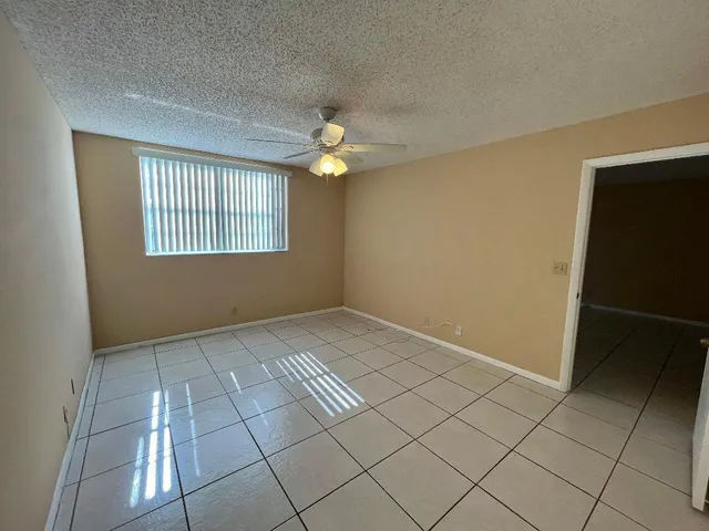 an empty room with windows and fan