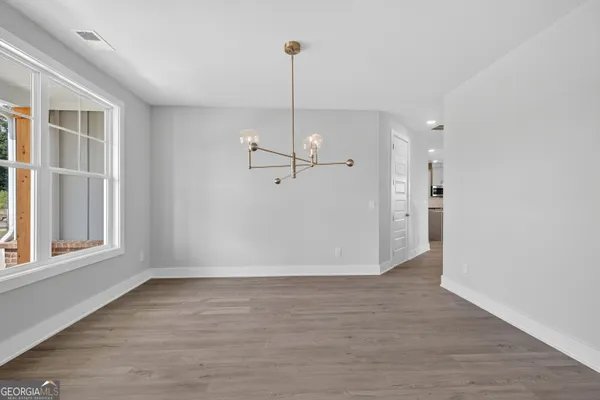 a view of empty room with wooden floor and ceiling fan