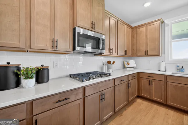 a kitchen with stainless steel appliances granite countertop a sink a stove a microwave a refrigerator and cabinets