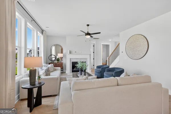 a living room with furniture a fireplace and a chandelier