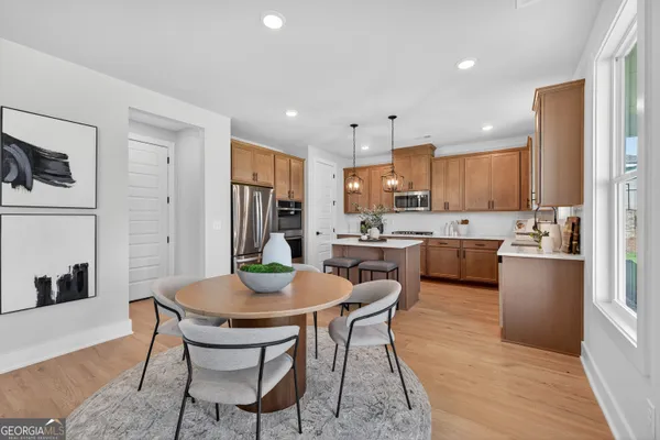 a kitchen with a dining table chairs and refrigerator
