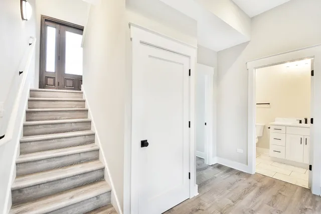 a view of a hallway with closet and wooden floor