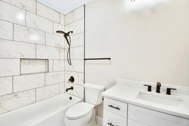 a bathroom with a toilet sink vanity and shower