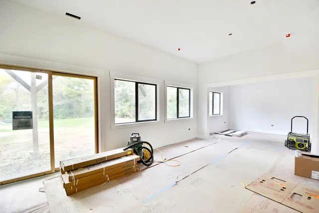 a view of a house with a big yard potted plants and large tree