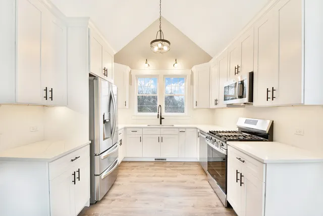 a kitchen with white cabinets and white appliances