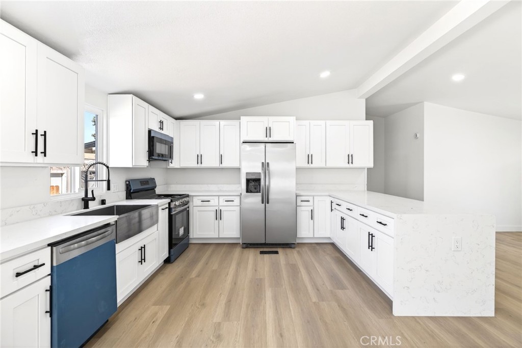 80 East Dawes Street, Unit 126 Perris, CA 92571 - Photo 12 of 39 a kitchen with granite countertop a white refrigerator oven a sink dishwasher and white cabinets with wooden floor