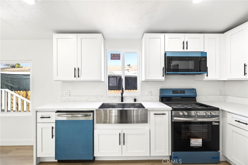 80 East Dawes Street, Unit 126 Perris, CA 92571 - Photo 13 of 39 a kitchen with stainless steel appliances a stove a microwave and white cabinets