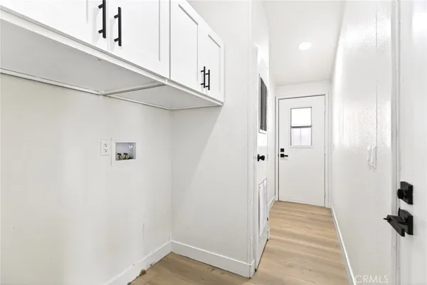 a view of a hallway with wooden floor and a cabinet