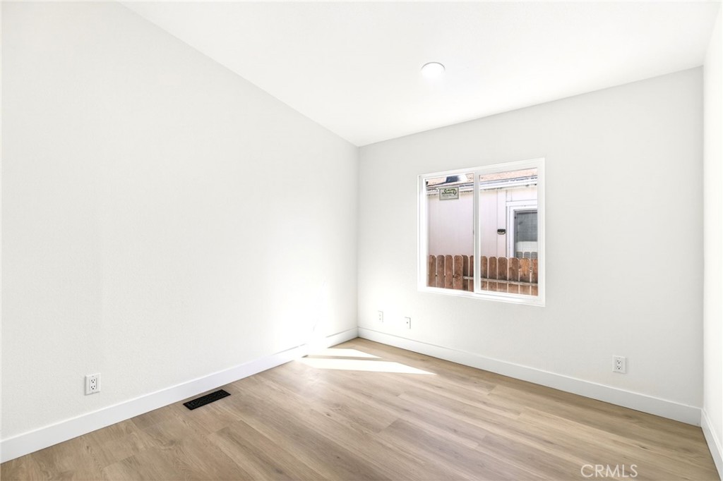 80 East Dawes Street, Unit 126 Perris, CA 92571 - Photo 23 of 39 an empty room with wooden floor and windows