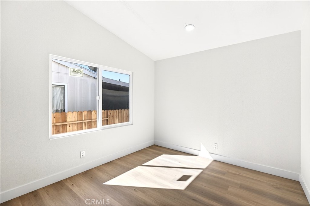80 East Dawes Street, Unit 126 Perris, CA 92571 - Photo 27 of 39 a view of an empty room with wooden floor and a window