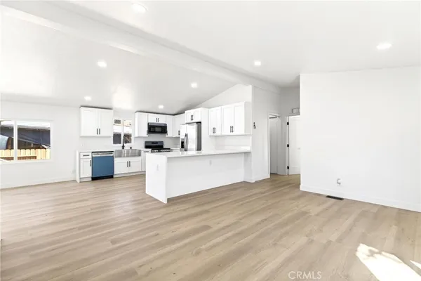 a view of kitchen with wooden floor and electronic appliances