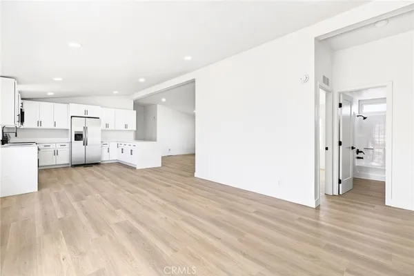 a view of a kitchen with wooden floor and a refrigerator