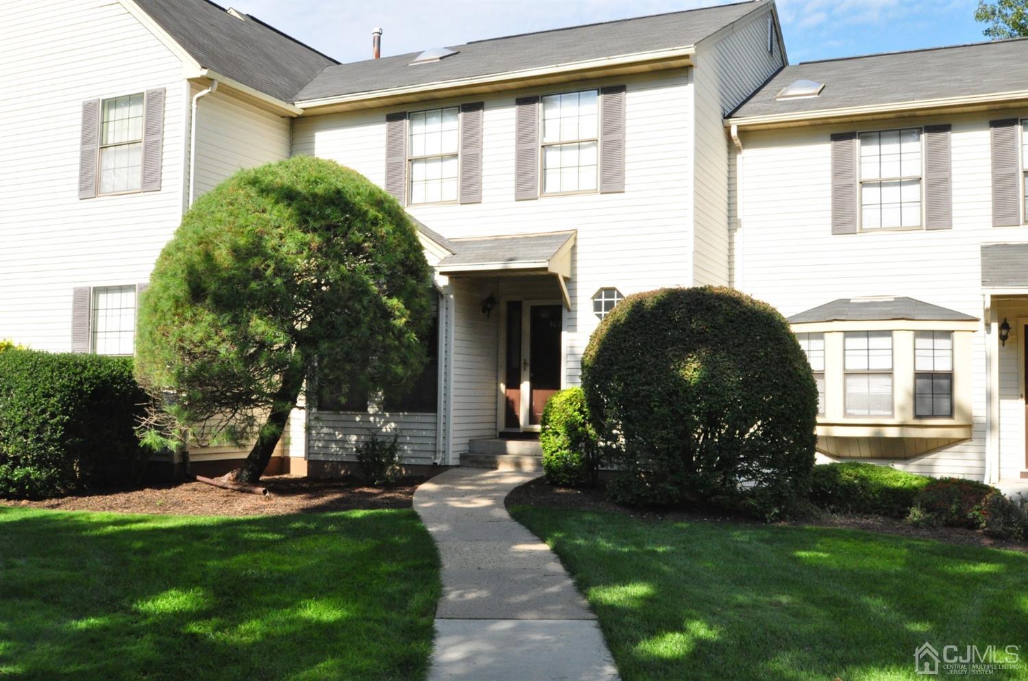 a front view of a house with a garden and plants